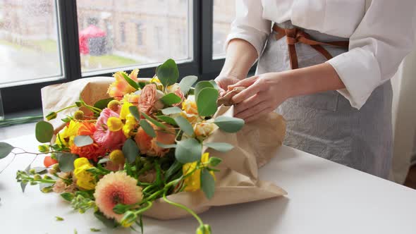 Woman Wrapping Flowers to Craft Paper at Home