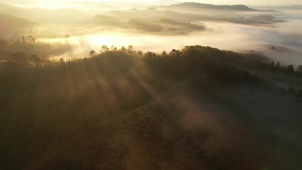 Aerial view of sunrise with fog above mountains