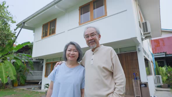 Senior elderly couple standing outdoor at house feeling happy and enjoy retirement life together.