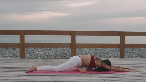 Lady Is Relaxing in Yoga Positions, Lying Face Down and Rising