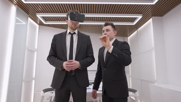 Smiling Happy Talented Architect Talking with Client in VR Headset Standing Indoors in Office