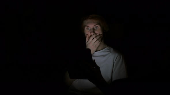 Shocked Redhead Man Using Tablet At Night, Wondering