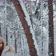 a Girl Throws a Snowball at a Guy in the Winter in the Forest - VideoHive Item for Sale