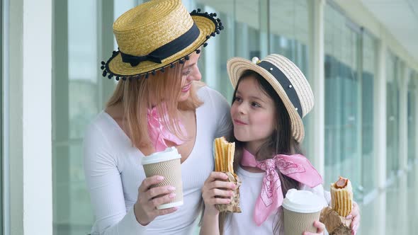 Mom and Daughter Eat Fast Food and Drink Coffee at the Airport While Waiting for the Plane