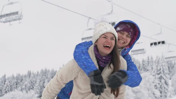 Two Young Women Enjoy the Snow Like Children