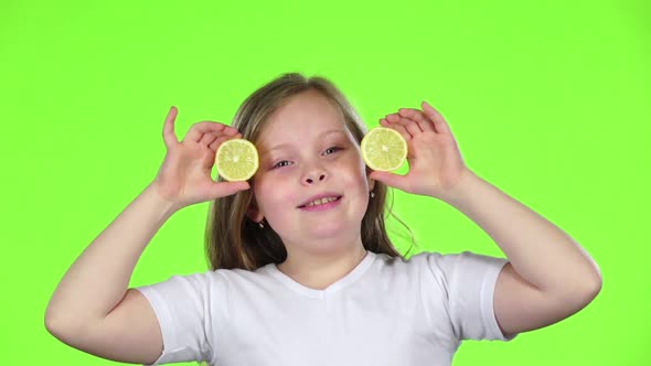 Little Girl Closes Her Eyes with a Lemon and Shows Different Emotions, Licks It and Croaks. Green