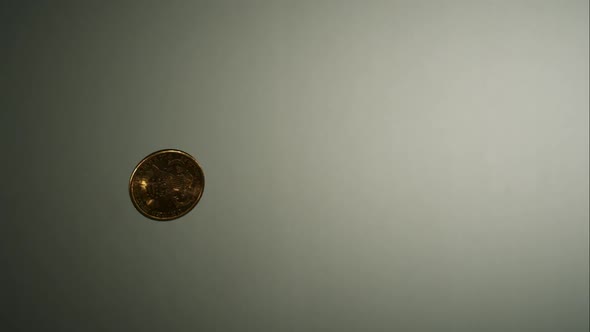 Golden coin flipping in the air in ultra slow motion