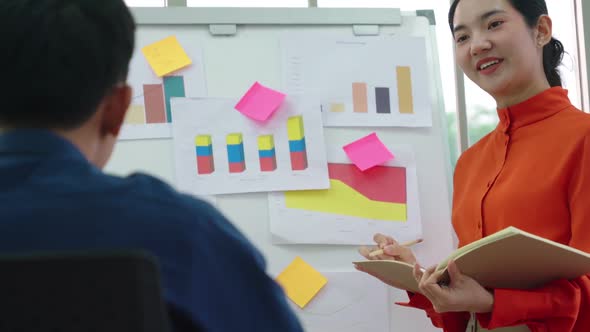 Young Woman Explains Business Data on White Board