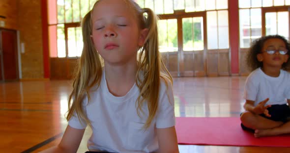 Schoolkids performing yoga on a exercise mat in school 4k