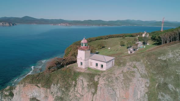 Aerial Panoramic View of White Lighthouse on the Rocky Cliff at Seaside