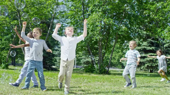 Happy Children Chasing Soap Bubbles at Outdoor Party alt