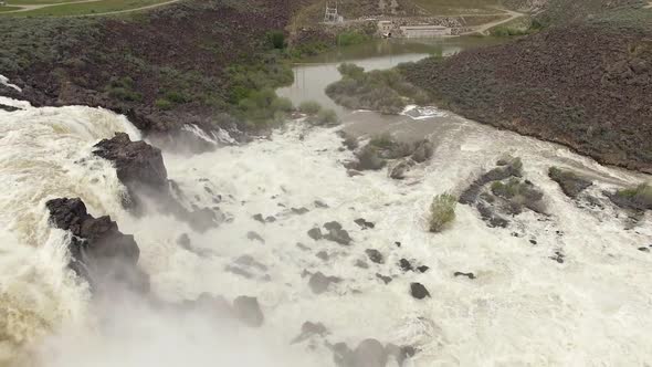 Rotating aerial view of waterfall raging at high runoff