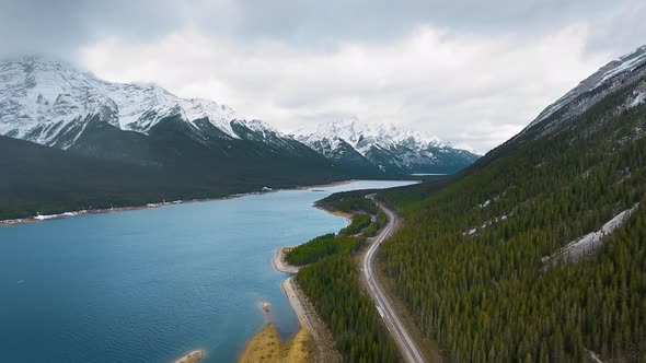 Aerial video showing forest on mountain slopes and road near Spray Lakes Reservoir, Alberta, Canada