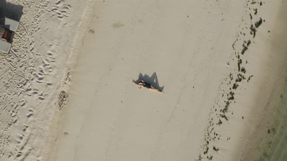 Aerial view of a blonde woman relaxing on the beach, Mauritius.