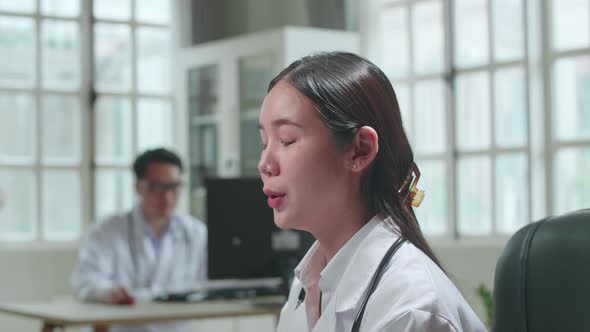 Asian Female Doctor Communicates With Patient By Video Link, Doctor Consults Patient