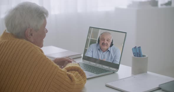 Two Male Friends Are Talking Online By Video Conference at Laptop with Internet, Staying Home During