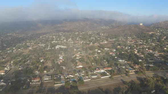 Aerial view of low fog over mountains in San Diego during sunrise