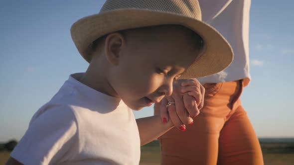 Mother and Little Son Holding Hands Into the Sunset. Child Have a Trust for Mother, Family Concept.