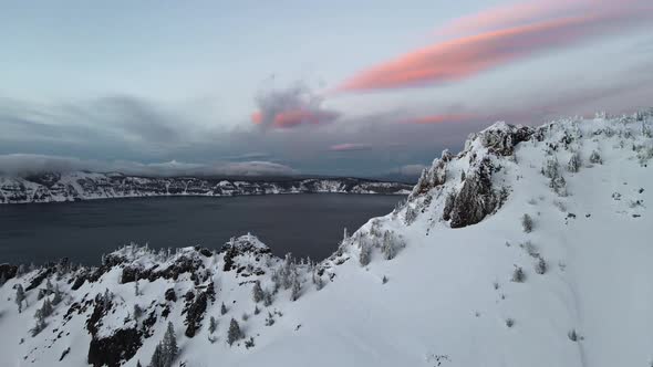 Aerial footage of ice covered caldera volcanic lake, Crater Lake, Oregon, USA