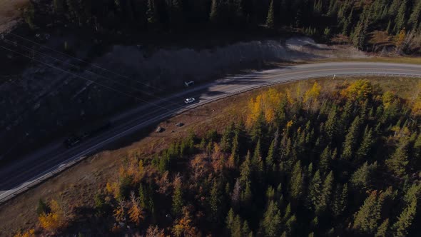 Car on mountain road by lake followed