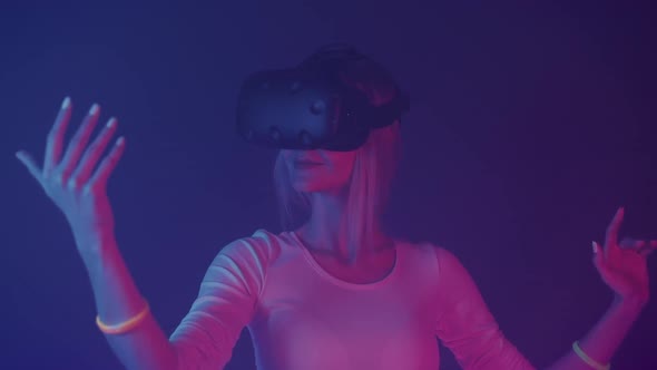 Happy Young Girl in Virtual Reality Headset Play Game and Moving Hands in Air Standing in the Room