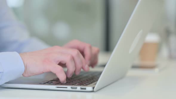 Close Up of Young Man Typing on Laptop