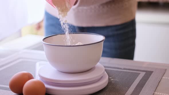 Dough Preparation  Woman Cook Pours Flour to Ceramic Bowl on Kitchen Scales