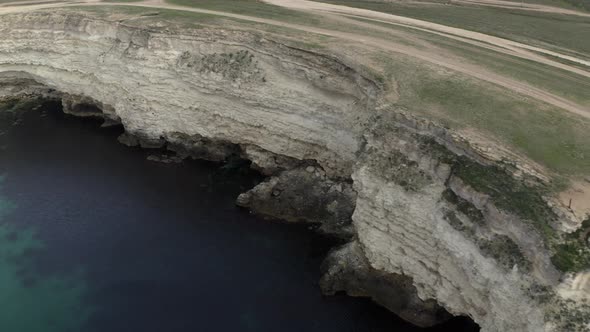 Aerial Shot Amazing Nature Scenery with Cliff Coastline Clear Transparent Sea Water and Flying Birds