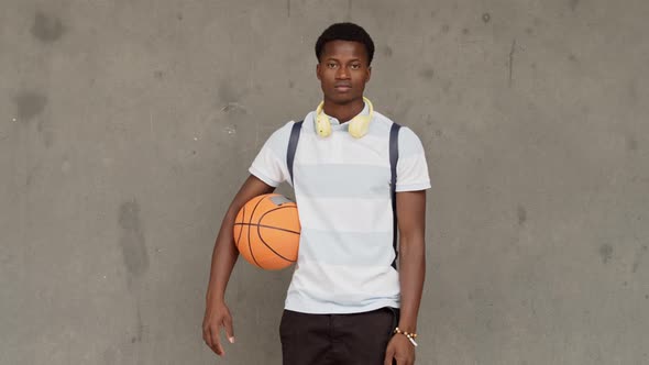 Portrait of a Teenage Afro Student Boy with a Backpack and a Basketball