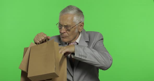 Elderly Businessman with Shopping Bags. Old Man in Formal Wear After Shopping