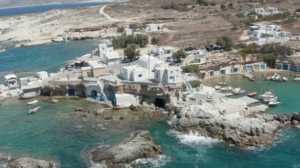 Scenic Greek Fishing Village with Typical White Houses and Waves Crashing Into the Bay