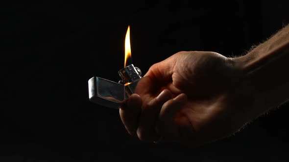 Male Hand Fires Flame With Cigarette Lighter, Gas Explosion or Arson Threat