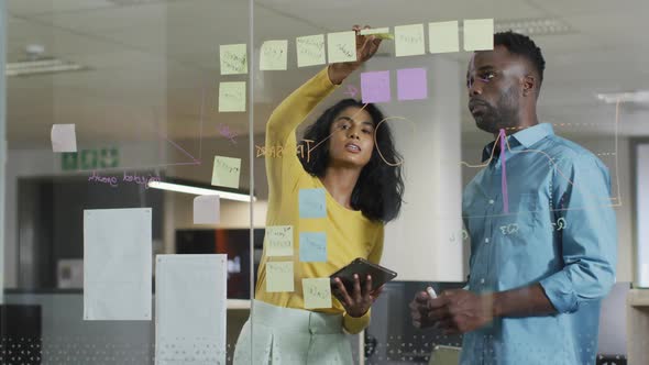 Video of happy diverse businesswoman and businessman brainstorming in office