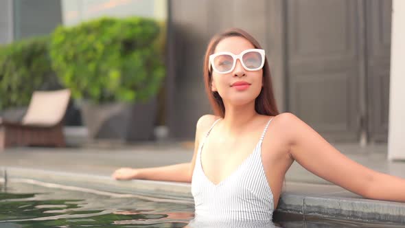 Young asian woman enjoy around outdoor swimming pool for leisure