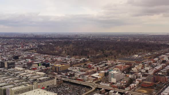 an aerial drone shot, panning right over Sunset Park Brooklyn. It's a cloudy day, with parks and The