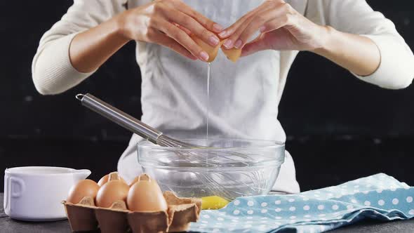 Woman breaking eggs into a bowl 4k