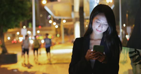 Businesswoman working on mobile phone in the street 