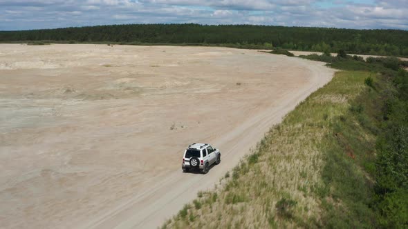 Aerial View of a Car Driving on Sand