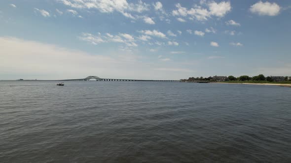 A low angle view of the Great South Bay Bridge starting from the grassy shore on a beautiful morning