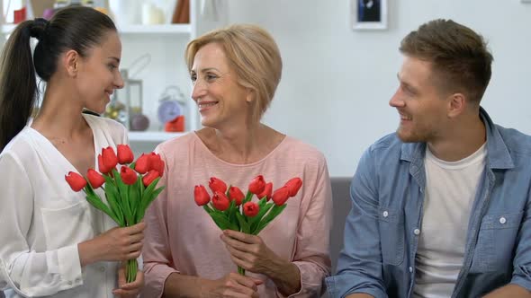 Aged Mother and Wife With Tulips Bouquets Sitting Near Male, Smiling on Camera