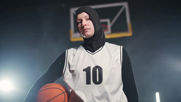 Handheld Portrait of a Young Arab Woman Basketball Player Holding a Ball in Her Hands and Looking at