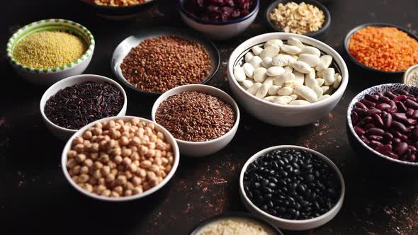 Various Superfoods in Smal Bowls on Dark Rusty Background