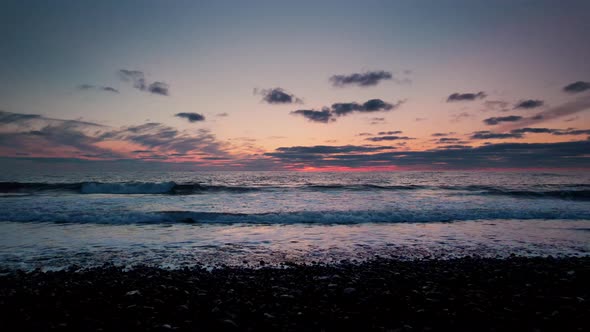 Drone Over Beach And Sea Towards Horizon At Sunset