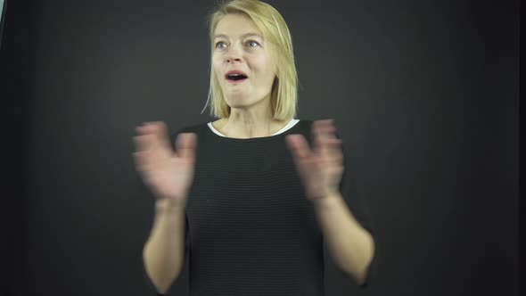 Attractive Blonde Claps Hands with Opened Mouth at Audition