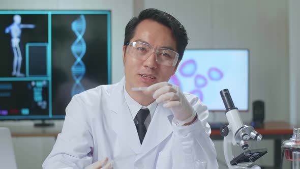 Asian Scientist Researching In The Laboratory With A Microscope And Explain To The Camera