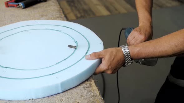 Closeup Hand Male Worker Cutting Foam Rubber for the Production of a Sofa in a Furniture Factory