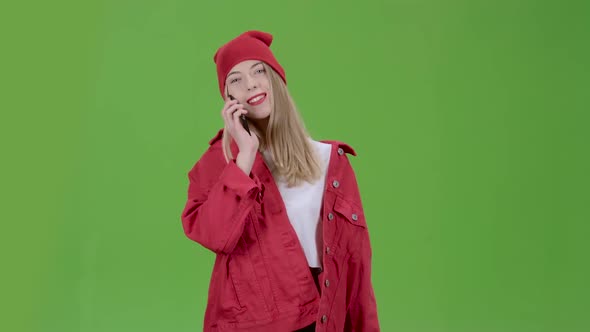 Teenage Stylish Girl Is Walking Down the Street and Talking on the Phone. Green Screen