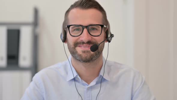 Portrait of Middle Aged Man with Headset Smiling at the Camera