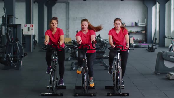 Group of Girls Performs Aerobic Training Workout Cardio Routine on Bike Simulators Cycle Training