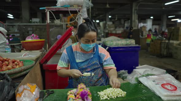 Thai Salesperson Creating A Jasmine Garland Inside The Pak Khlong Talat (Flower Market) In Bangkok